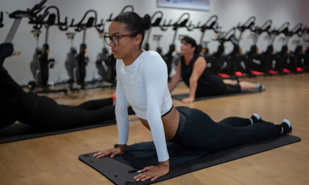 chica estirando abdominales durante clase de yoga