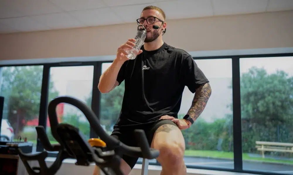 coach hidratandose durante una sesión de spinning