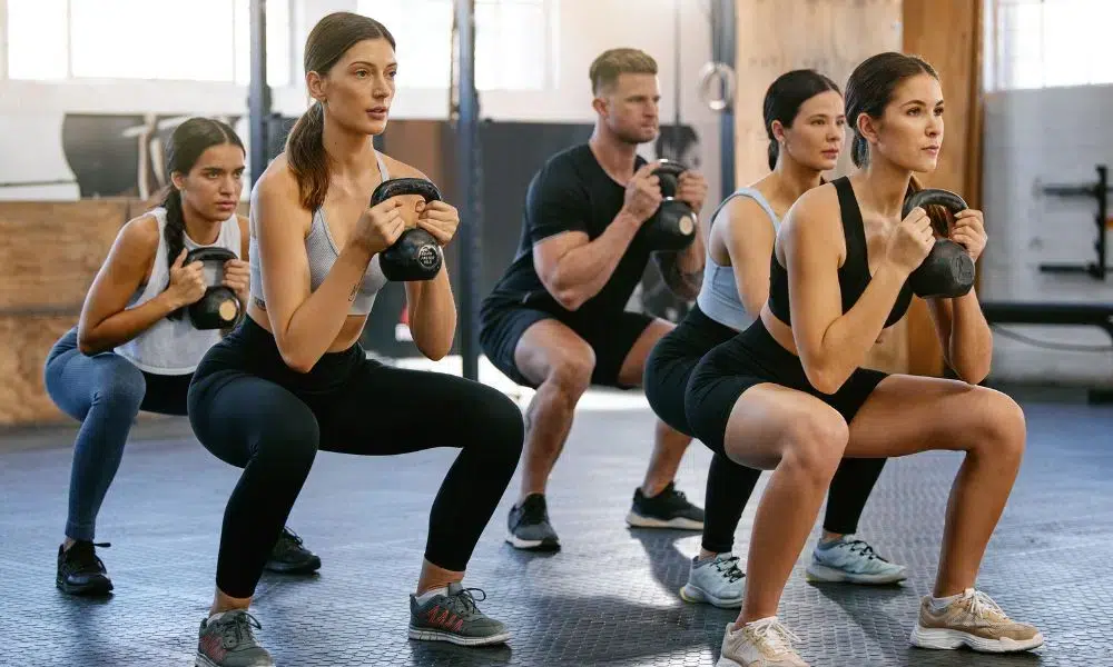 mujeres haciendo squats con ketlebell