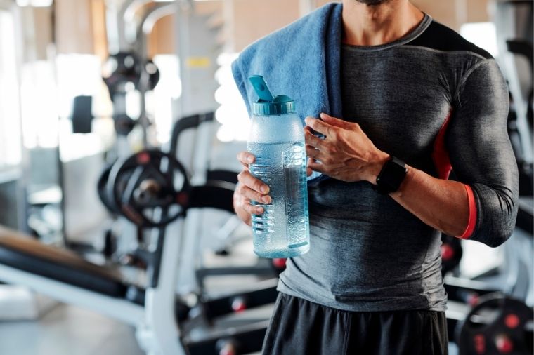 homme avec bouteille d eau en salle de sport