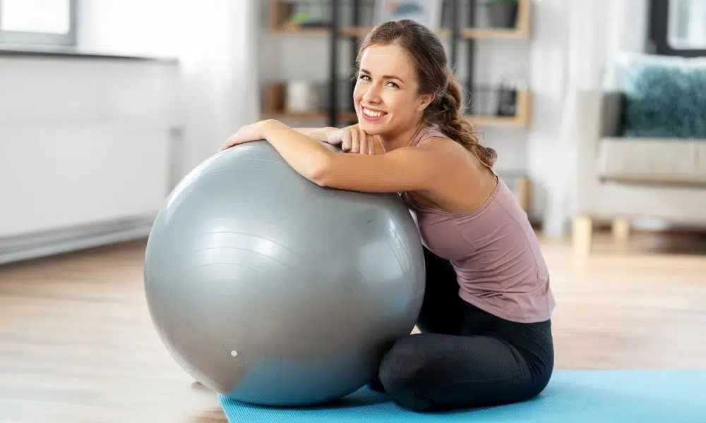 mujer sentada con balon suizo