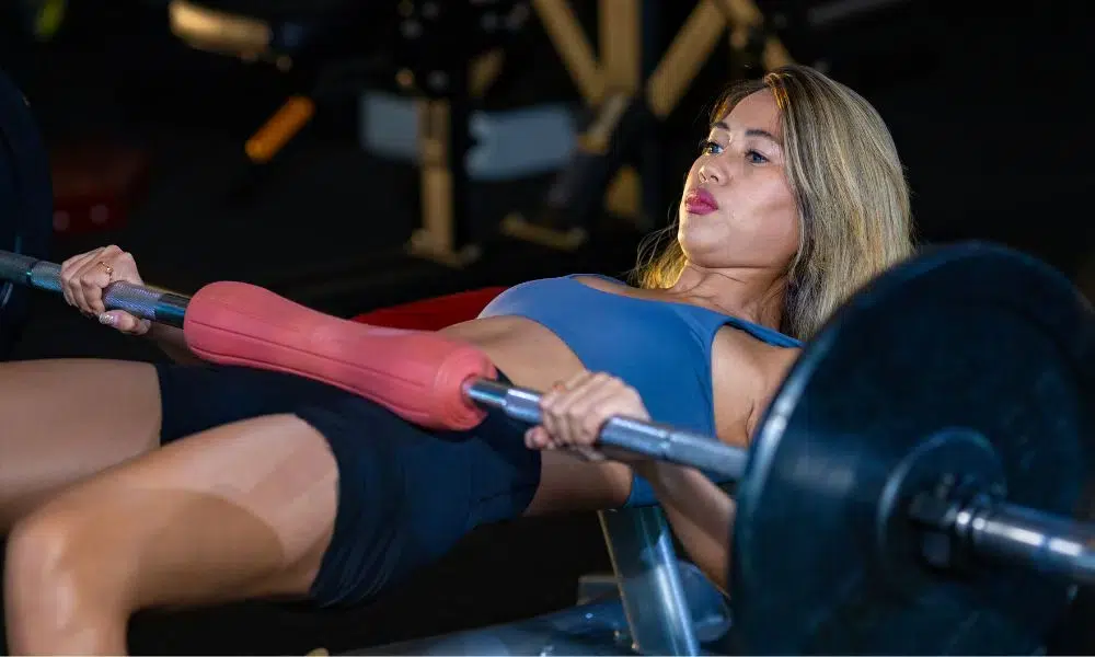 chica rubia haciendo hip thrust con cojín protección de caderas