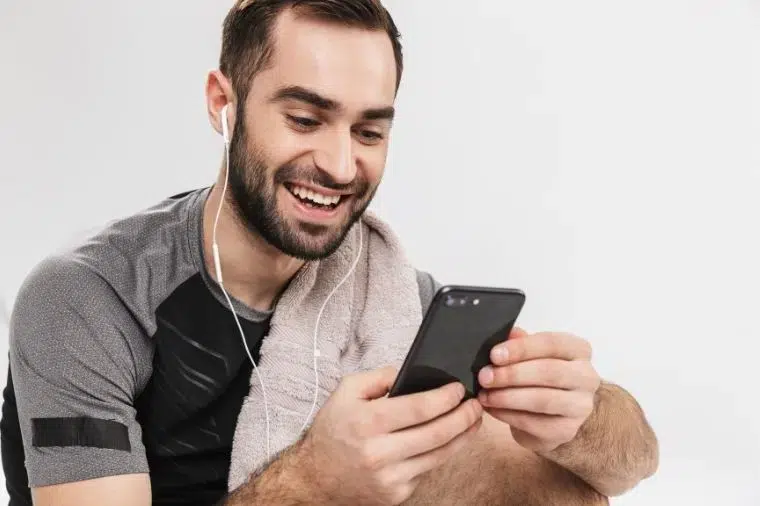hombre mirando su smartphone y sonriendo