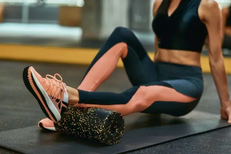 chica usando foam roller en el gym