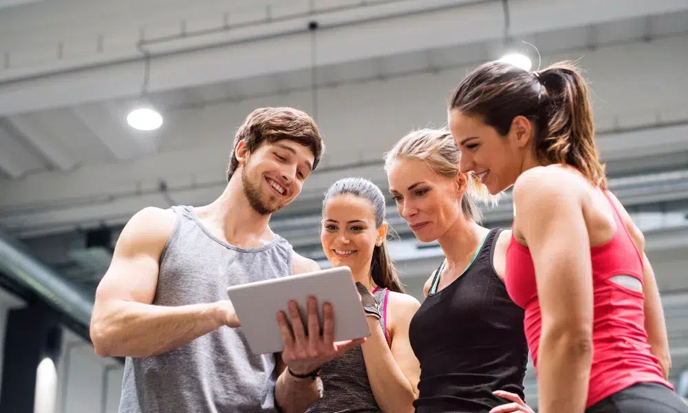 entrenador mostrando tablet a 3 chicas