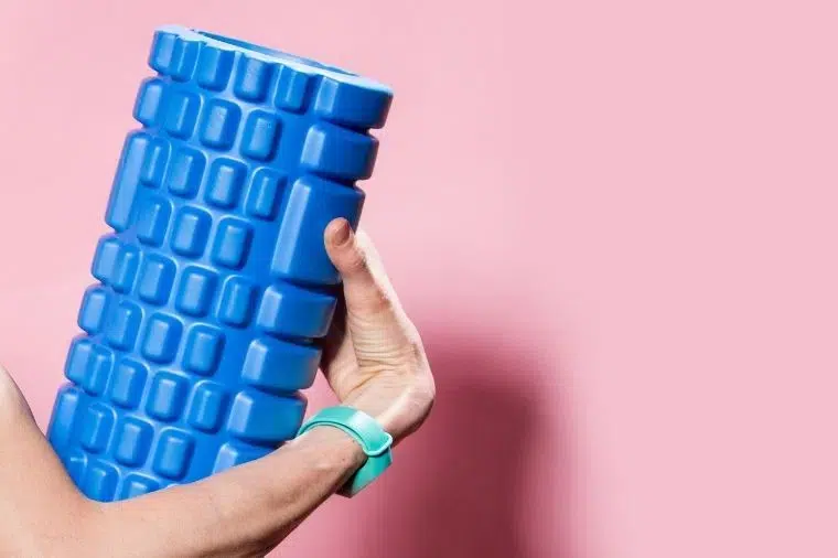 foam roller azul con fondo rosa