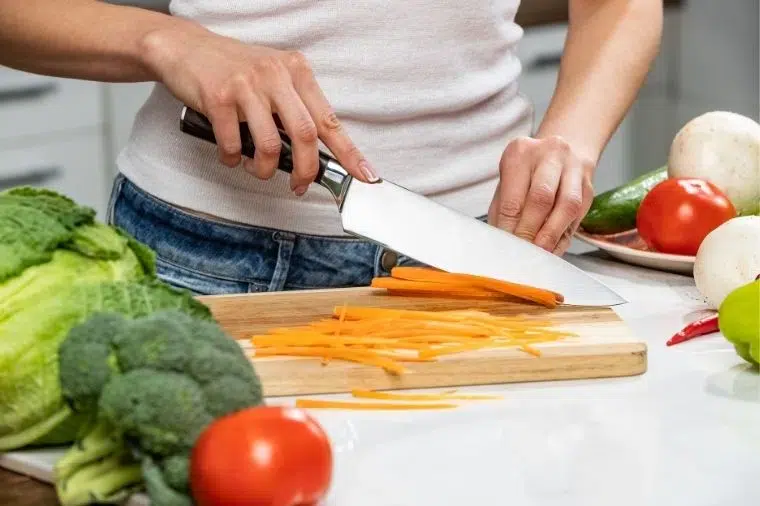 hombre cortando una zanahoria en juliana