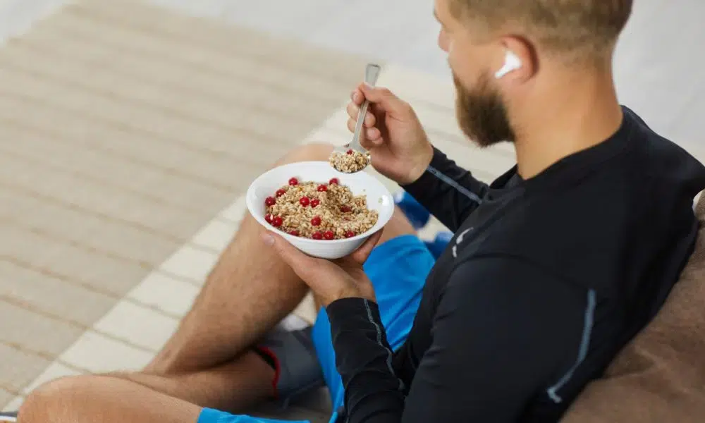 deportista comiendo muesli y frutos rojos