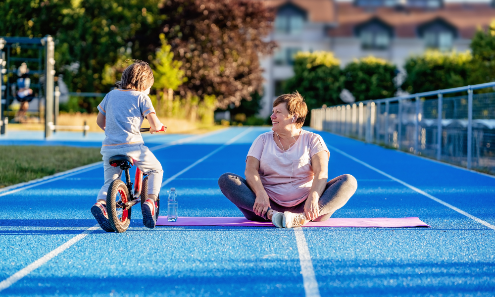 mujer haciendo pilates con su nieto al lado